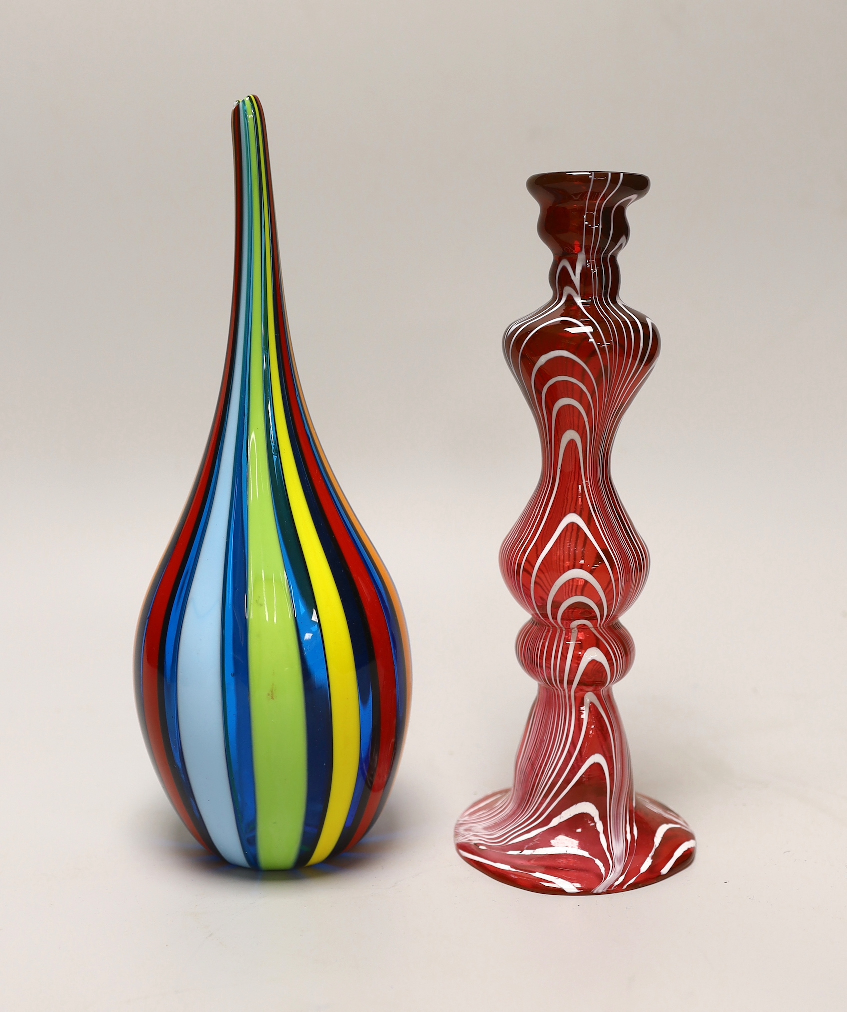 A Victorian hollow ruby glass candlestick with combed trailed decoration together with a Venetian glass striped vase (no maker's mark), the largest 25cm high